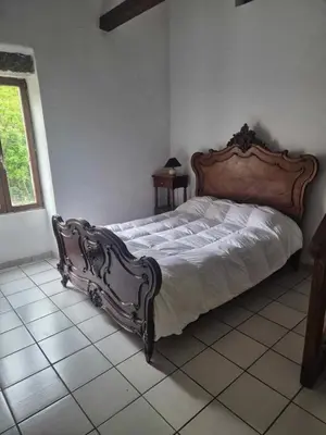 a bedroom with a large bed with a wooden headboard at Maison de caractère in Pietrapola