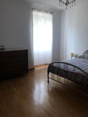 a bedroom with a bed and a dresser and a window at Maison de caractère in Pietrapola