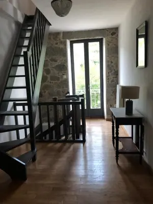 a room with a staircase and a table with a lamp at Maison de caractère in Pietrapola