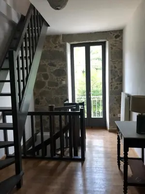 a room with a staircase with a window and a table at Maison de caractère in Pietrapola