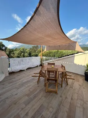 a patio with a table and chairs on a roof at Appartement A madonna in Santa-Lucia-di-Moriani