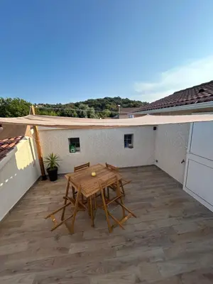 a white house with a bench in the yard at Appartement A madonna in Santa-Lucia-di-Moriani