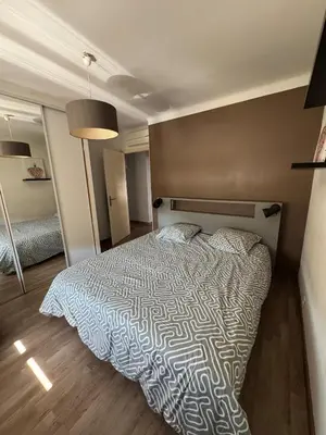 a bedroom with a bed with a white comforter at F3 parking gratuit Clim port 5min aéroport 10min in Ajaccio