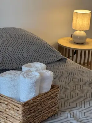 a basket of towels sitting on top of a bed at F3 parking gratuit Clim port 5min aéroport 10min in Ajaccio