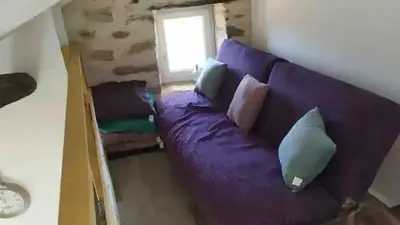 a purple couch with pillows in a living room at Vue sur les montagnes Corses in Castellare-di-Mercurio