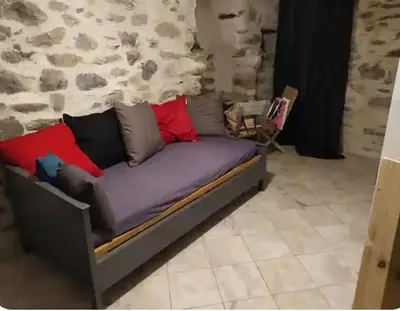 a couch with pillows on it in a room at Vue sur les montagnes Corses in Castellare-di-Mercurio