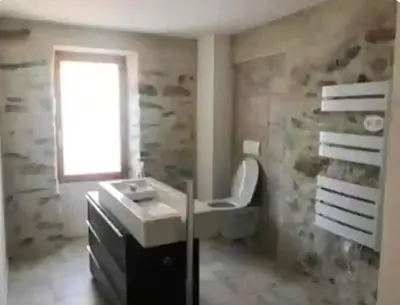a bathroom with a sink and a toilet and a window at Vue sur les montagnes Corses in Castellare-di-Mercurio