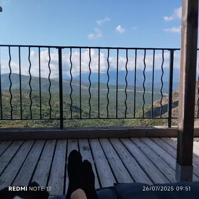 a person laying on a wooden deck looking out at the ocean at Vue sur les montagnes Corses in Castellare-di-Mercurio