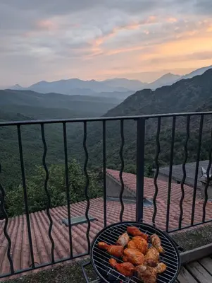 a grill with some food on top of a balcony at Vue sur les montagnes Corses in Castellare-di-Mercurio