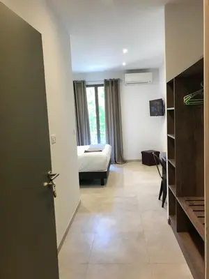 a bedroom with a bed and a room with a door at Hôtel du Golfe Pinarello in Pinarellu