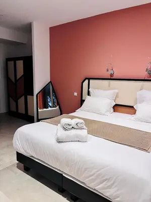 a hotel room with two beds with towels on them at Hôtel du Golfe Pinarello in Pinarellu