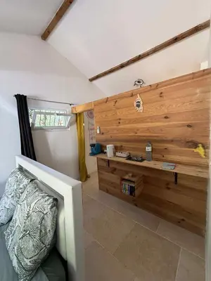 a room with a bed and a wooden wall at Chambre d'Hôtes Chez Tania et Benoit in Borgo