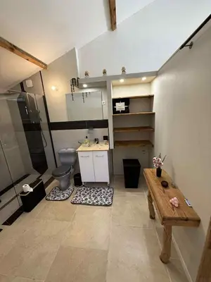 a bathroom with a toilet and a wooden table at Chambre d'Hôtes Chez Tania et Benoit in Borgo