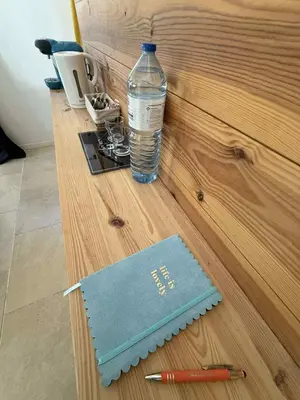 a bottle of water and a notebook and a pen at Chambre d'Hôtes Chez Tania et Benoit in Borgo