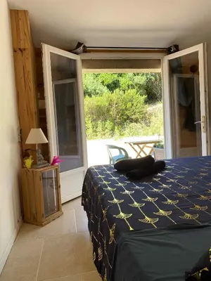 a bedroom with a bed and a large window at Chambre d'Hôtes Chez Tania et Benoit in Borgo