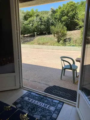 an open door with a table and a bench outside at Chambre d'Hôtes Chez Tania et Benoit in Borgo