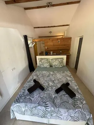 a bedroom with a bed with two black shoes on it at Chambre d'Hôtes Chez Tania et Benoit in Borgo