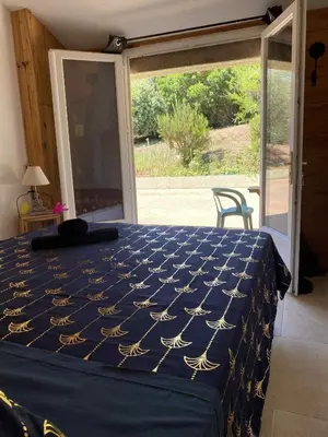 a bedroom with a bed with a blue and gold bedspread at Chambre d'Hôtes Chez Tania et Benoit in Borgo