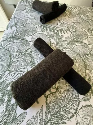 a group of three towels on a bed at Chambre d'Hôtes Chez Tania et Benoit in Borgo