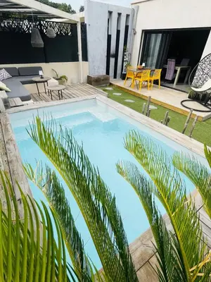 a swimming pool with palm trees in front of a house at Villa Maria in Borgo