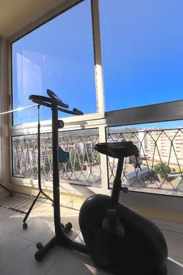 a room with a chair in front of a window at Spacieux Appartement Vue Mer et Montagne en dernier étage avec Terrasse - Parking et Wifi in Ajaccio