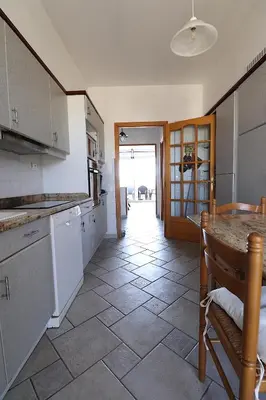 a kitchen with a counter and a table in it at Spacieux Appartement Vue Mer et Montagne en dernier étage avec Terrasse - Parking et Wifi in Ajaccio