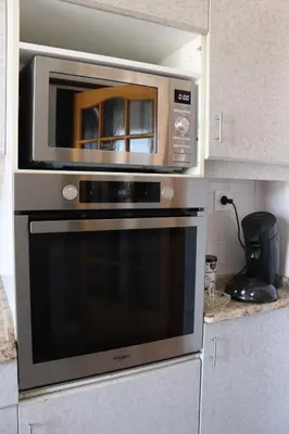 a microwave oven sitting on top of a kitchen counter at Spacieux Appartement Vue Mer et Montagne en dernier étage avec Terrasse - Parking et Wifi in Ajaccio
