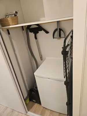 a closet with a white refrigerator and a shelf at Maison Bois in Grosseto-Prugna