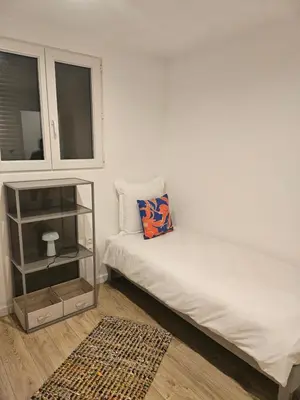 a small bedroom with a bed and a shelf at Maison Bois in Grosseto-Prugna