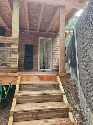 a porch with wooden stairs and a fence at Maison Bois in Grosseto-Prugna