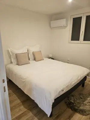 a bedroom with a large white bed with two pillows at Maison Bois in Grosseto-Prugna