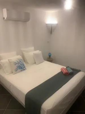 a bed with white sheets and pillows in a room at A Teghja in Figari