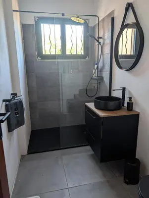a bathroom with a black sink and a shower at Andemu Pianottoli Caldarello in Pianottoli-Caldarello