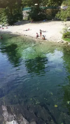 a group of people laying on the beach in the water at Bergerie Restaurée in Corte