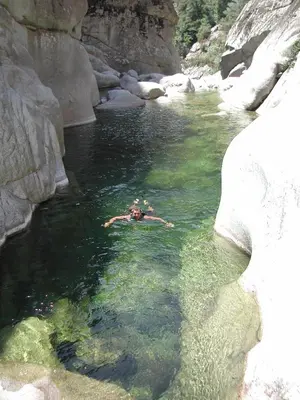 a person swimming in a body of water at Bergerie Restaurée in Corte