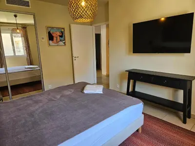 a bedroom with a bed and a flat screen tv at Appartement Paolina Vue Mer Sari-Solenzara Corse in Sari Solenzara