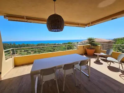 a white table and chairs on a balcony with a view at Appartement Paolina Vue Mer Sari-Solenzara Corse in Sari Solenzara