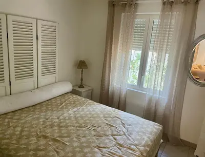 a bedroom with a bed and a window and a mirror at La Milange de Porto vecchio in Porto-Vecchio