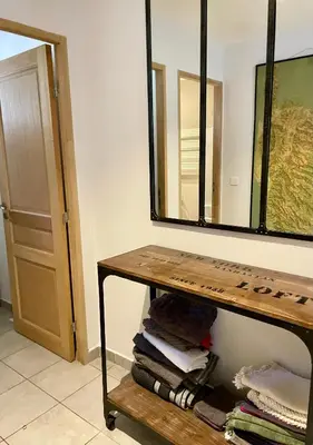 a bathroom with a table and a large mirror at La Milange de Porto vecchio in Porto-Vecchio