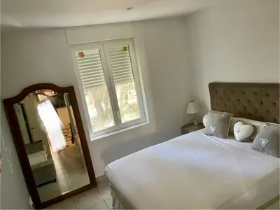 a bedroom with a bed and a mirror and a window at La Milange de Porto vecchio in Porto-Vecchio