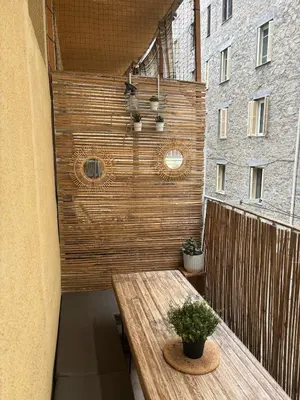 a patio with a wooden table on a balcony at Eden Studio in Ajaccio