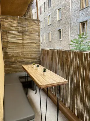 a wooden table on a balcony with a wooden fence at Eden Studio in Ajaccio