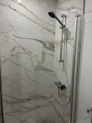 a bathroom with a shower with marble walls at Eden Studio in Ajaccio