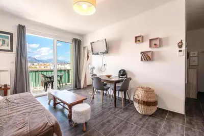 a room with a bed and a table with a view at Azur Ajaccien - Proche du port avec parking in Ajaccio