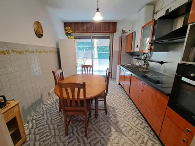 a kitchen with a wooden table and chairs in it at Appartement Ajaccio centre, climatisé, parking in Ajaccio