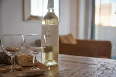 a bottle of wine and two wine glasses on a table at Helena - Bright 2Br Trottel Beach by foot - by TGB in Ajaccio