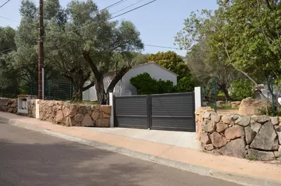 a gate on a stone wall in front of a house at Appartement Porto-Vecchio in Porto-Vecchio