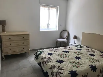 a bedroom with a bed and a dresser and a window at Appartement Porto-Vecchio in Porto-Vecchio