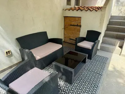 two chairs and a couch on a patio at Appartement Porto-Vecchio in Porto-Vecchio