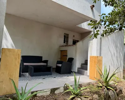 a patio of a house with chairs and a couch at Appartement Porto-Vecchio in Porto-Vecchio